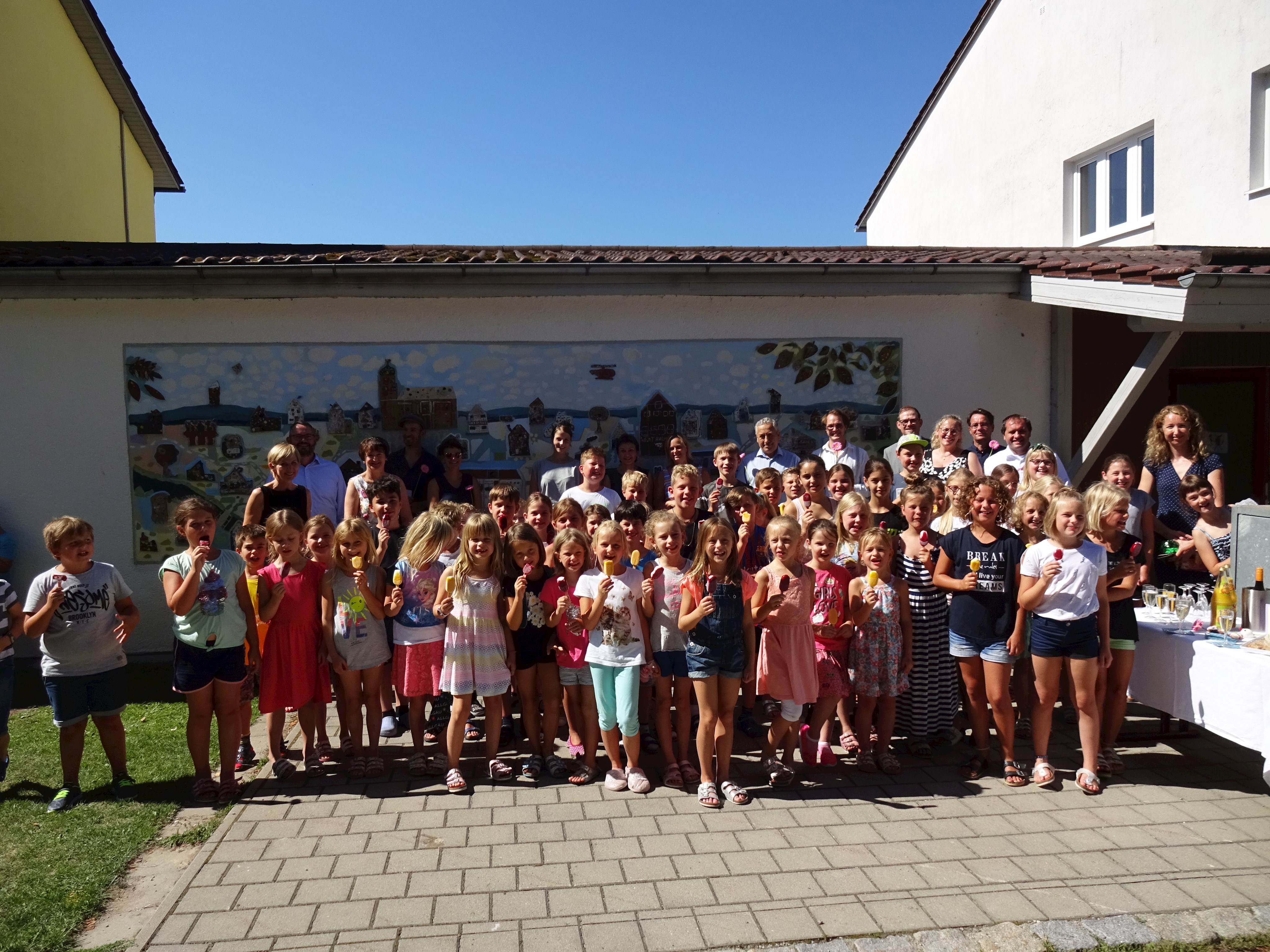 Alle freuen sich über das gelungene Werk - ein Teil der Kinder zusammen mit den beiden Künstlern den Klassenlehrerinnen und den Ehrengästen.JPG Leider haben wir keinen Alternativtext zu diesem Bild, aber wir arbeiten daran.